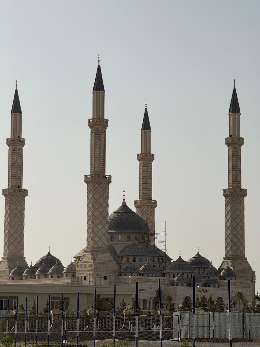 A large four-minaret mosque on the open plains