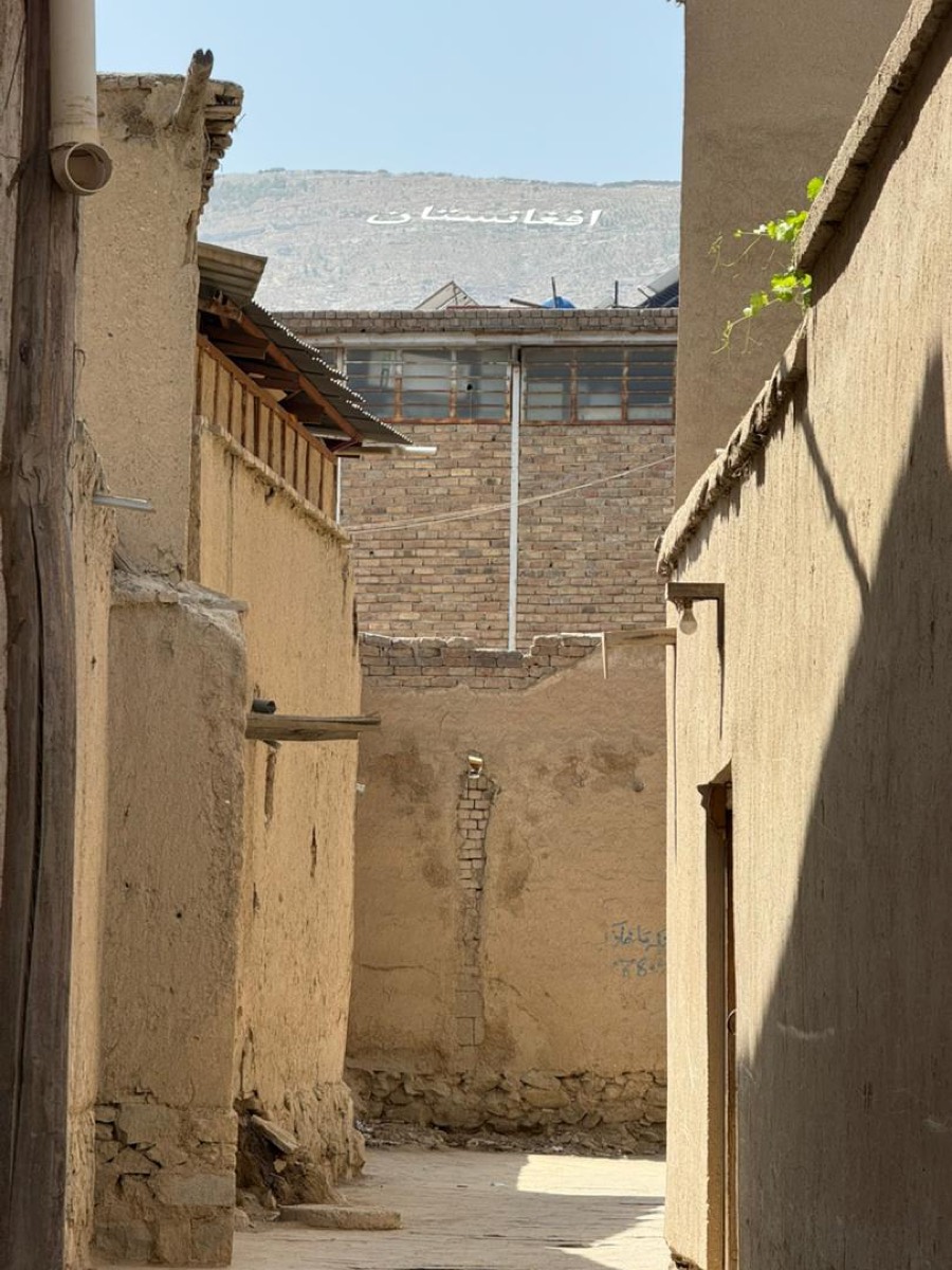 A narrow mud-brick alley in an old Afghan town