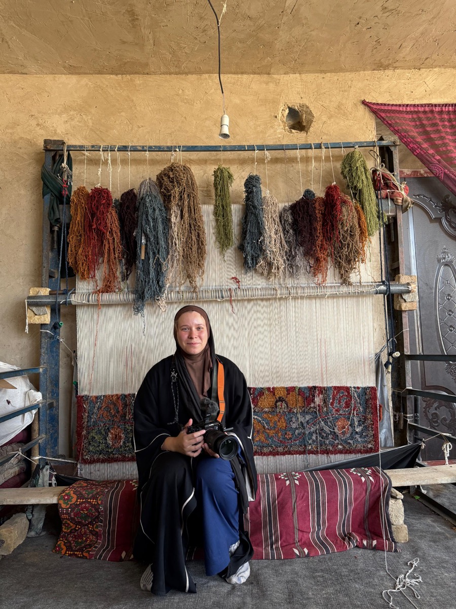 A weaver seated at a traditional carpet loom